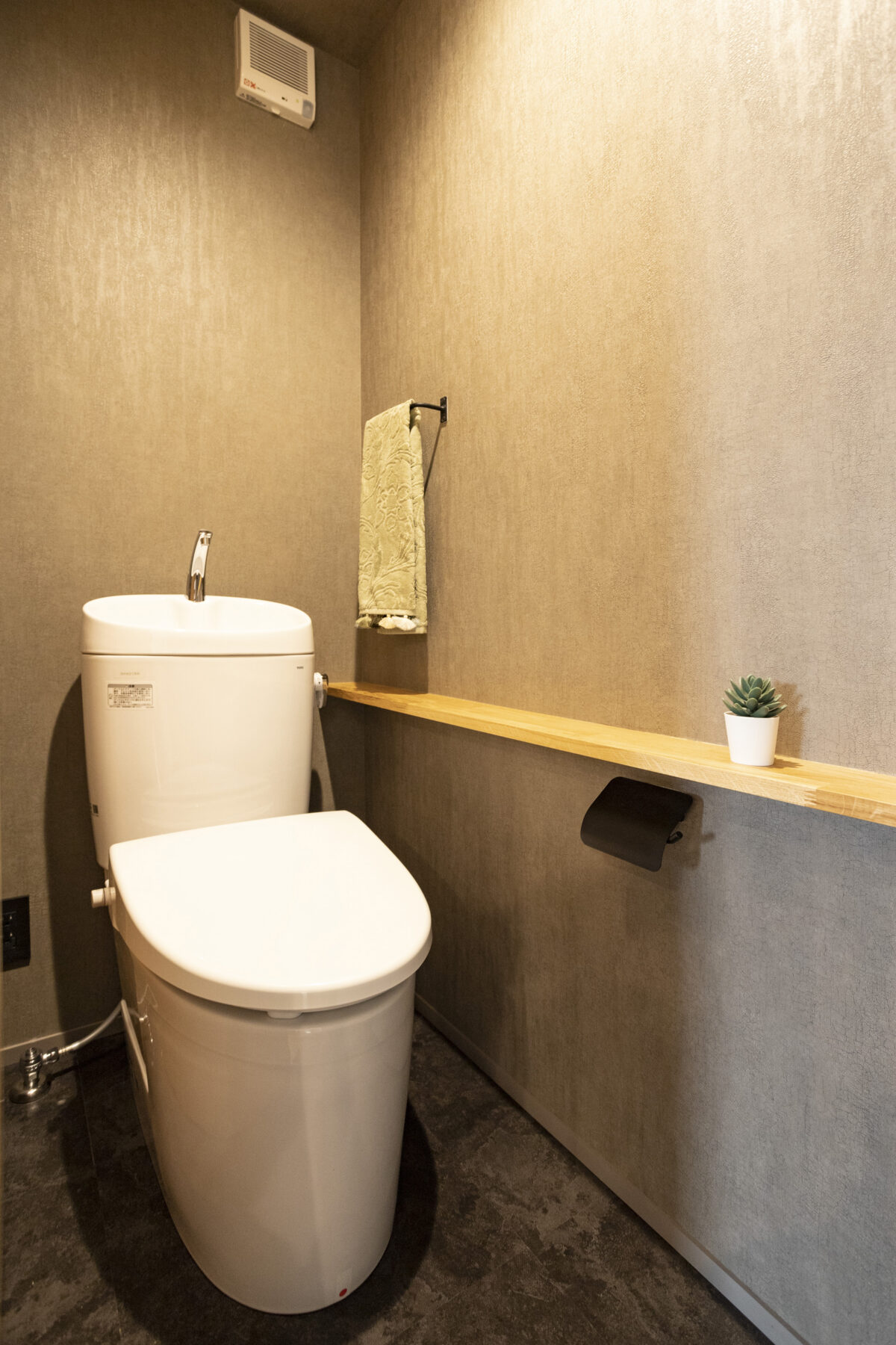 >グレー系のカラーで統一されたスタイリッシュなトイレ。ちょっとした小物が置ける造作カウンターが便利です。　写真