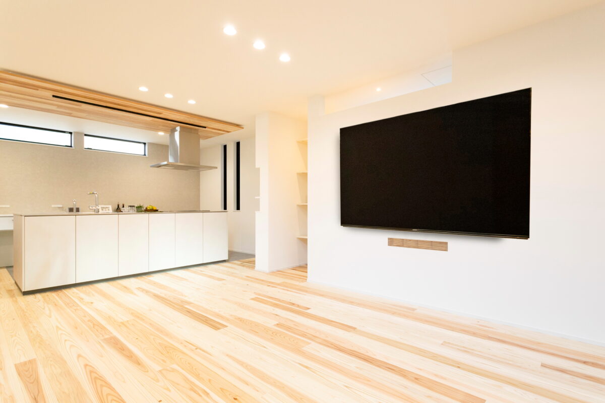 >AV機器や配線類を見せない壁掛けテレビ。テレビ下の格子から背面に置いてある機器にリモコンの赤外線を通します。 写真
